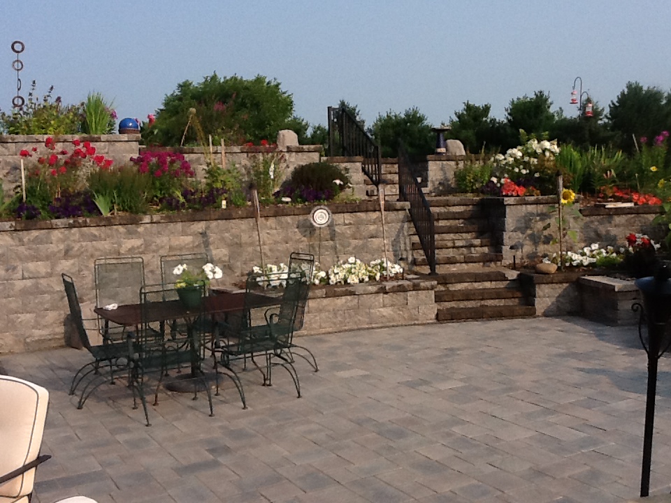 wide-shot of patio with seating and rock stairway in brick retaining wall