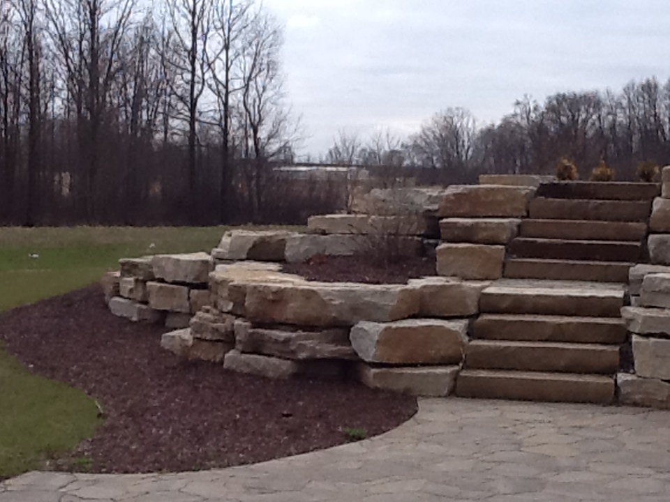 stone steps leading to walkway in two-level rock retaining wall