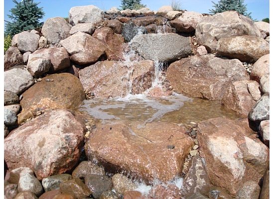 large stacked rock feature with water streaming down