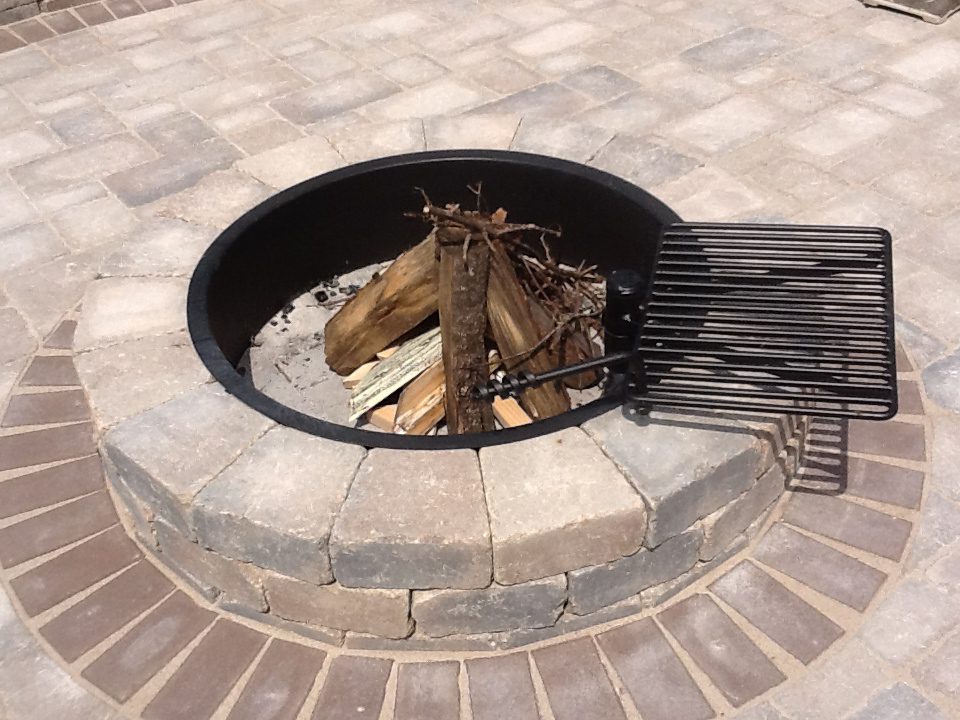 close-up of circular brick fire pit in the middle of a patio