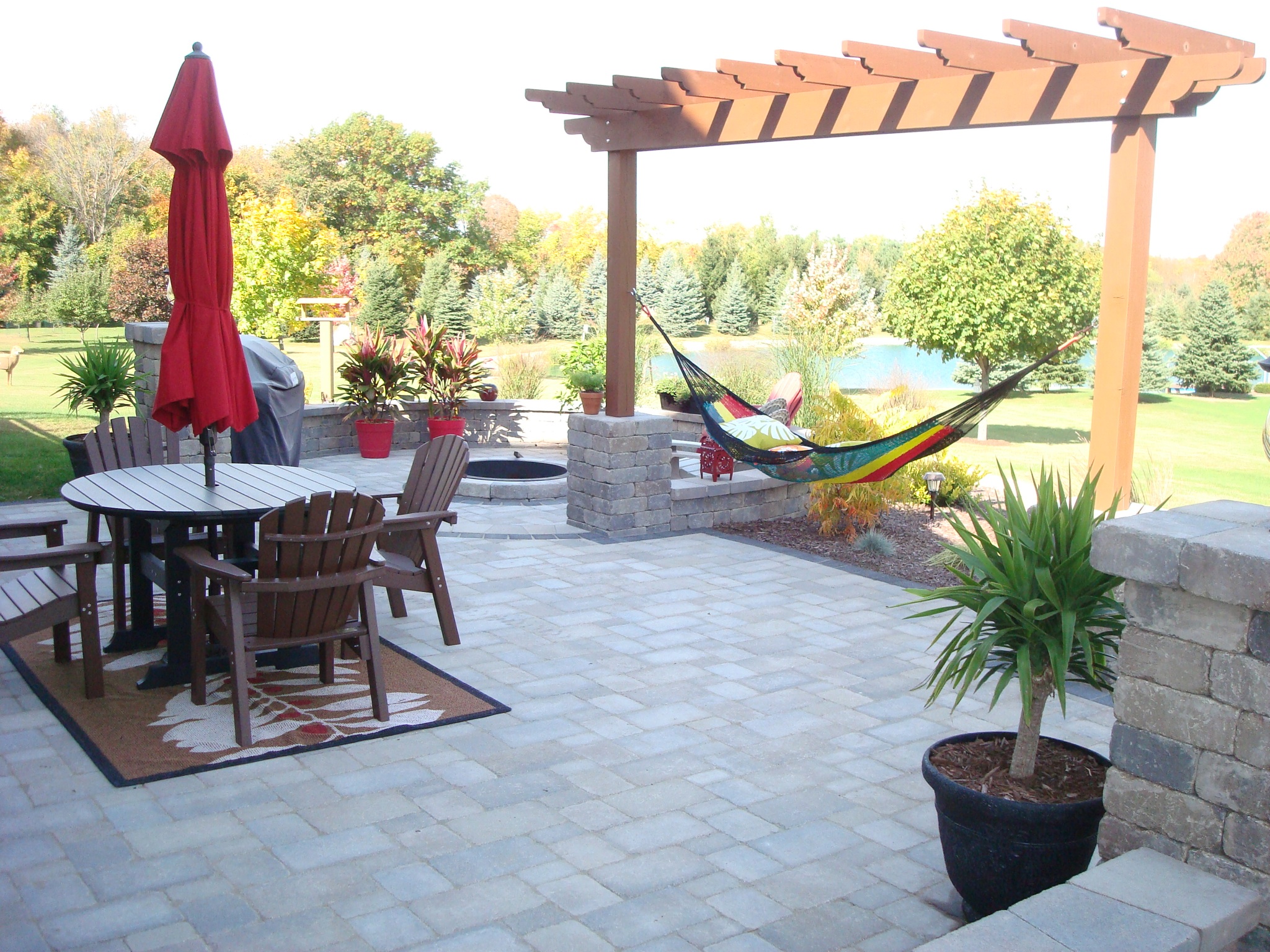 tiled patio with table, umbrella and chairs and hammock