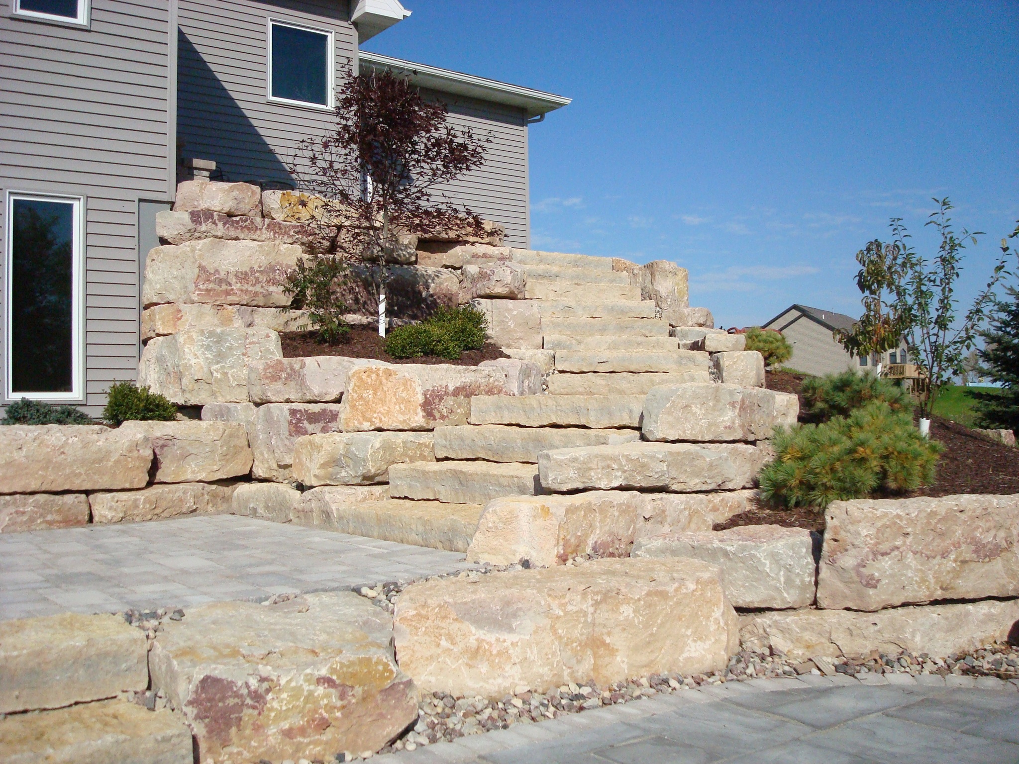 rock steps leading from house along stone retaining walls leading to stone patio