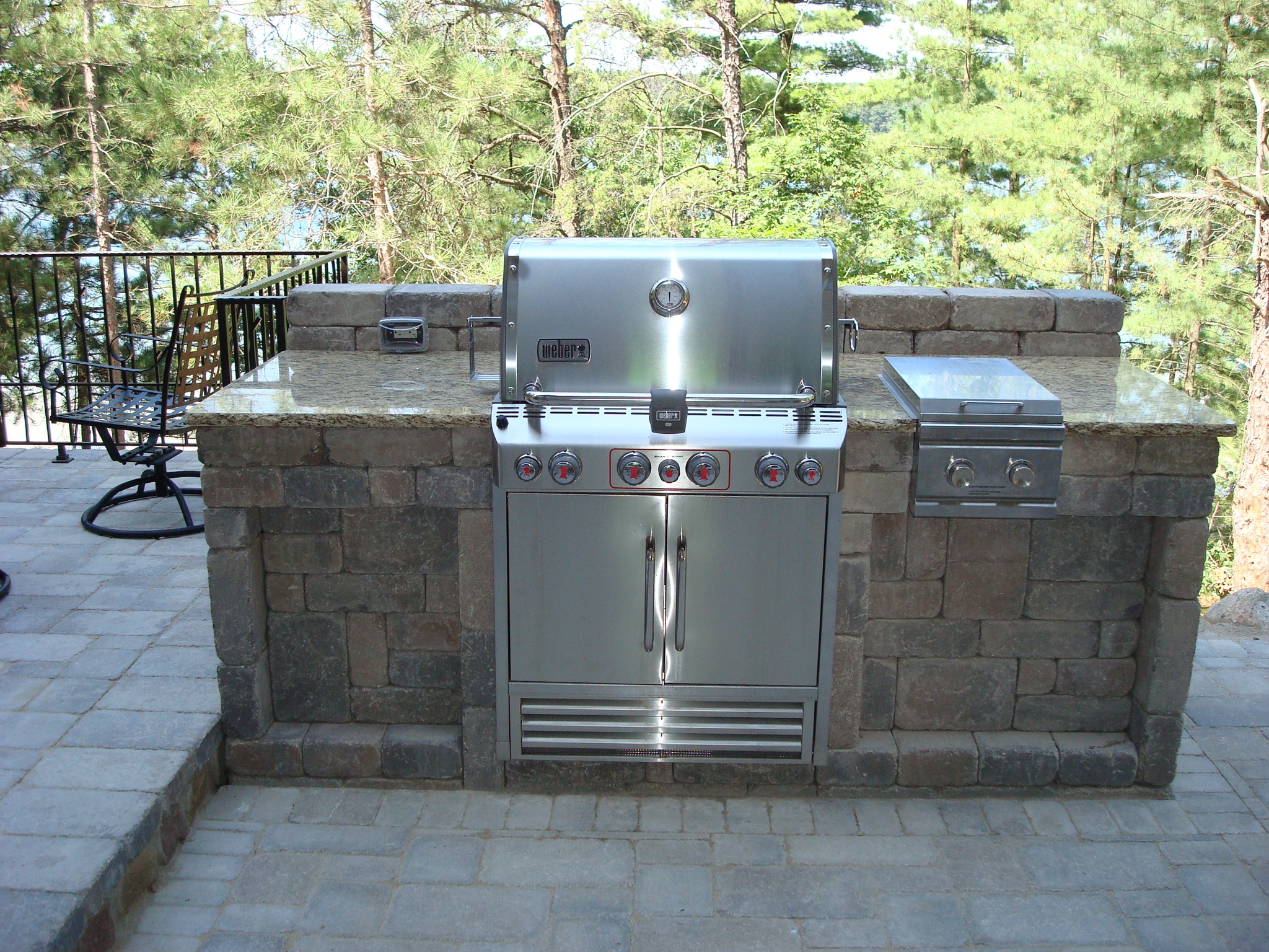 grill in outdoor kitchen area overlook patio and woods