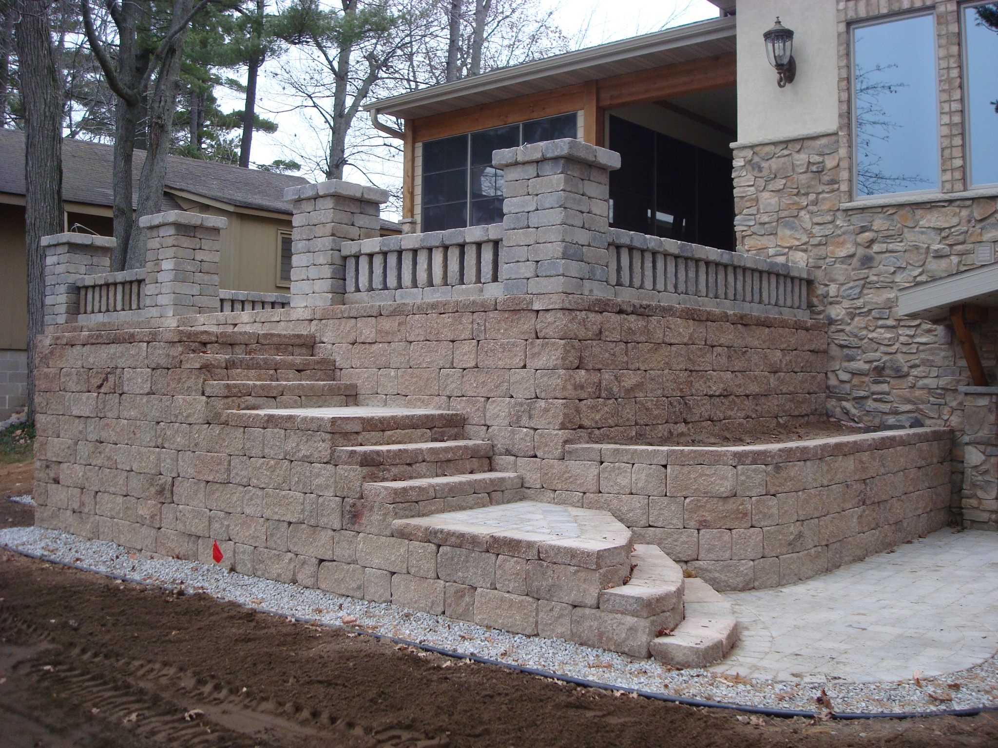 brick retaining walls with short rock steps leading up to patio