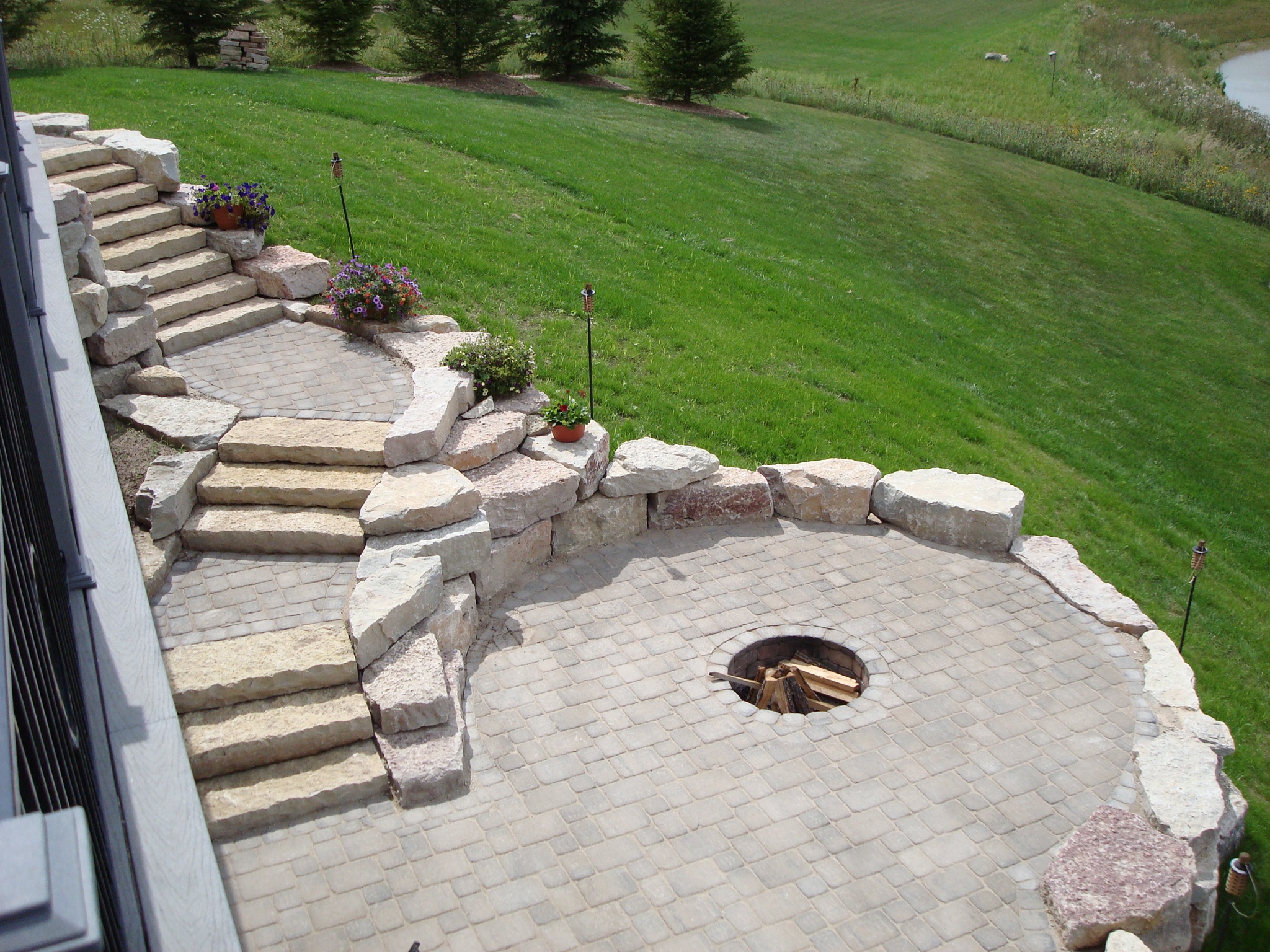 multi-level patio with fire pit in circular area