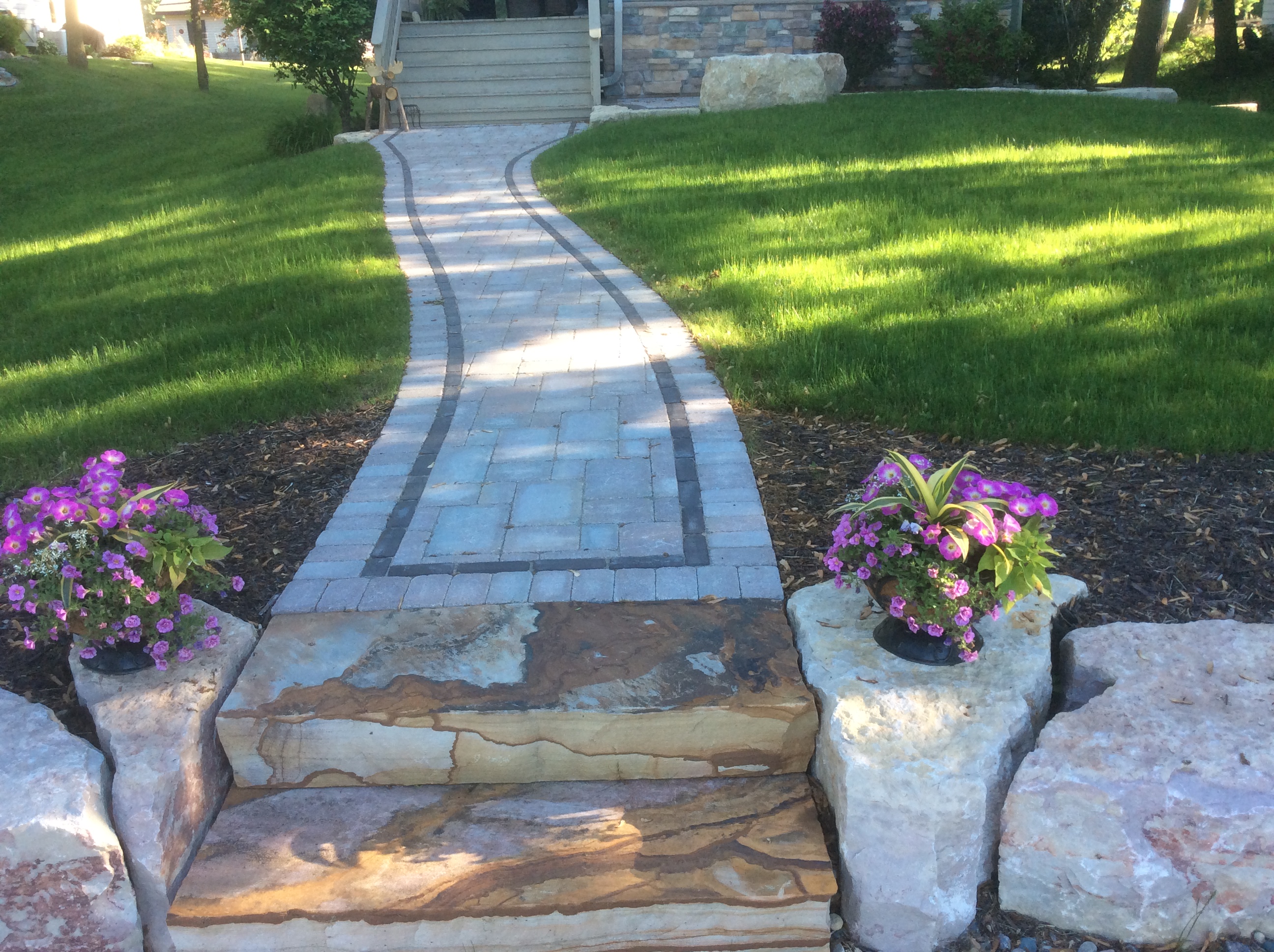 bordered walkway leading from decorative rock steps to front door stairs