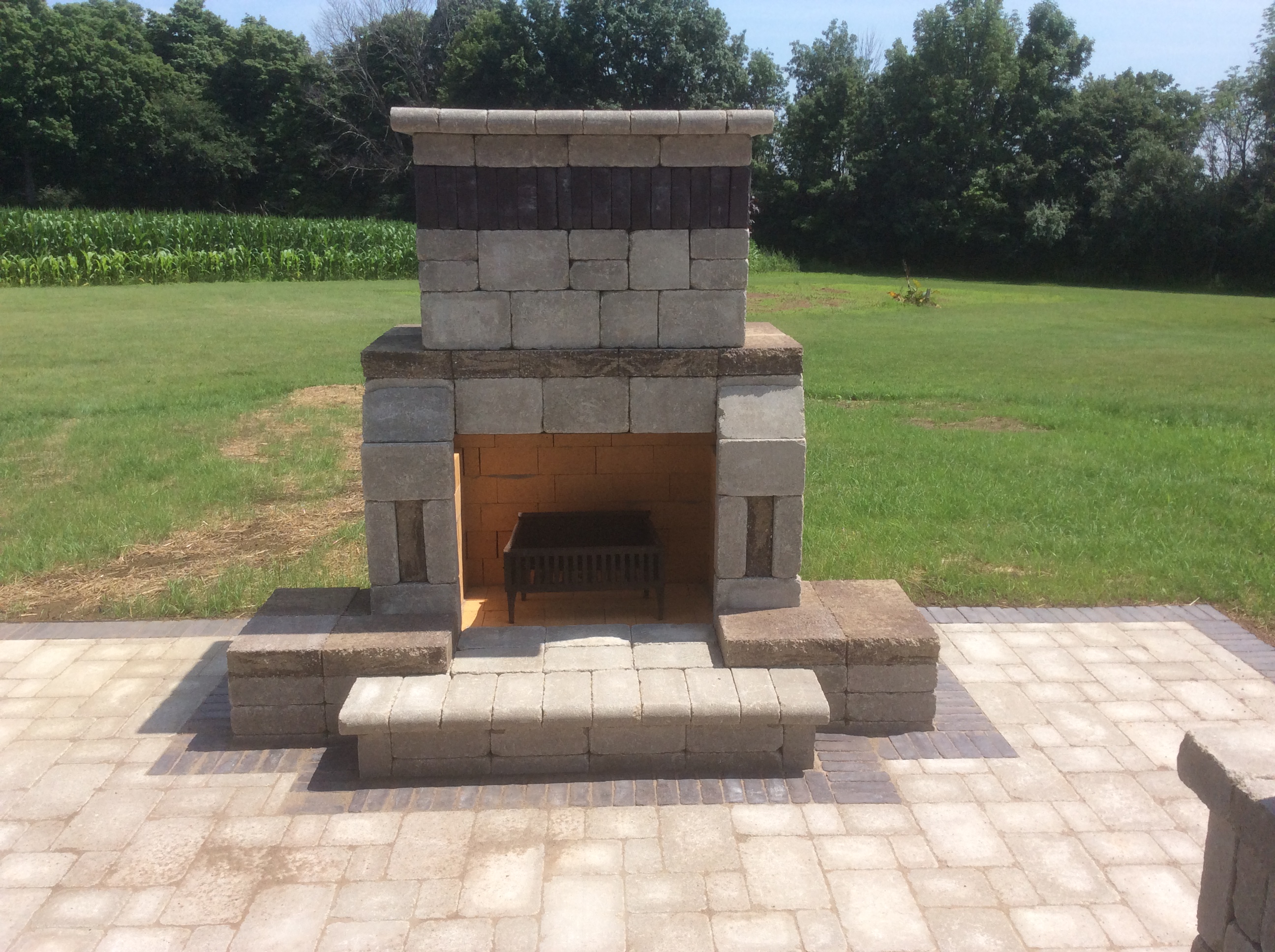 large outdoor brick fireplace in open rock tile patio