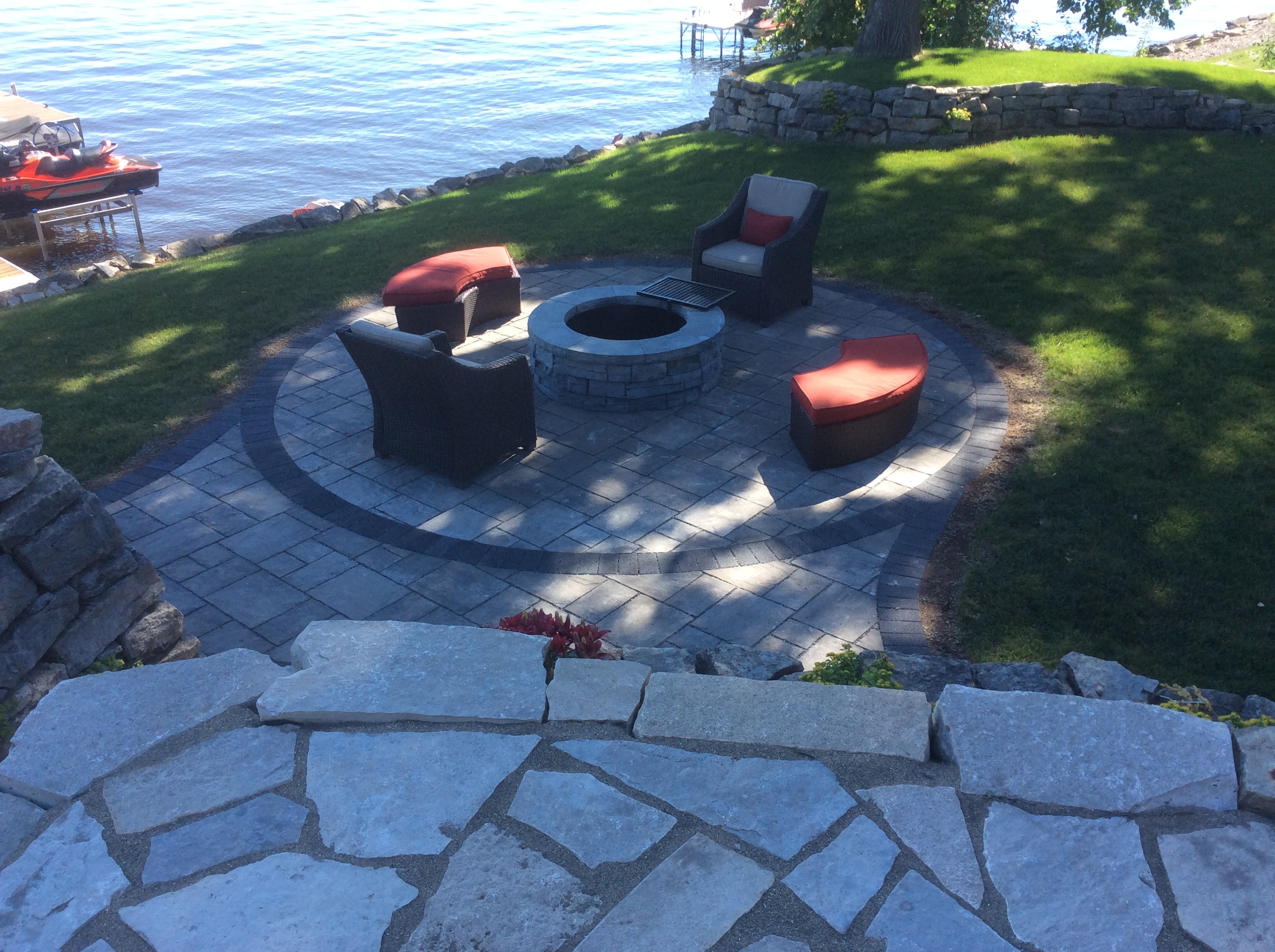 fire pit by chairs down by lake on small circle patio